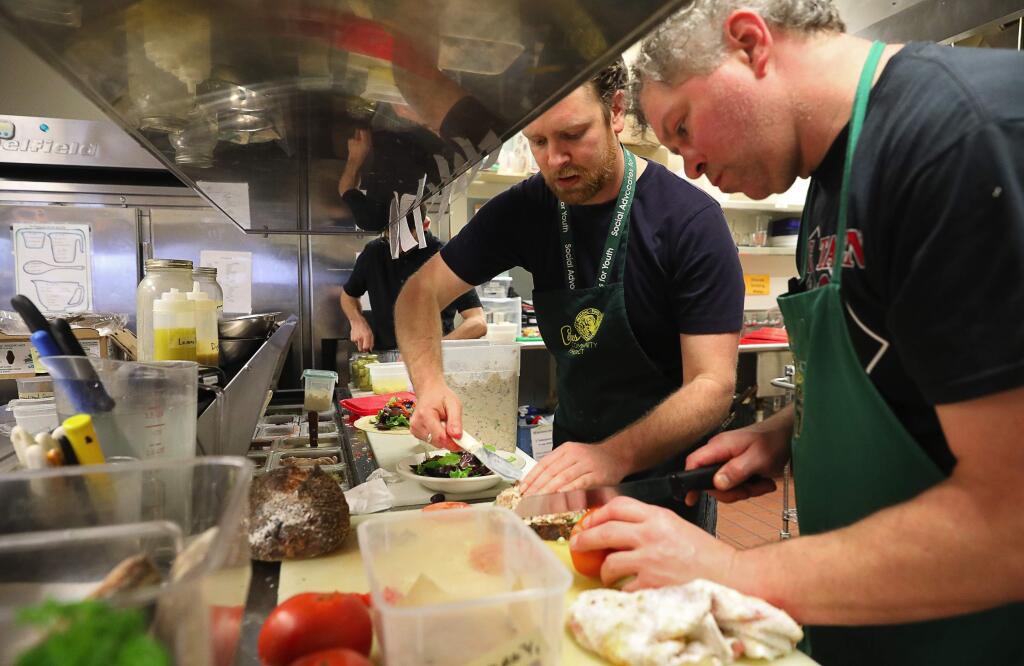 Ceres Community Project Cafe manager Cole Bendinelli, left, and Brad Smisloff prepare food for cafe customers in Santa Rosa on Thursday, March 1, 2018. (Christopher Chung/ The Press Democrat)