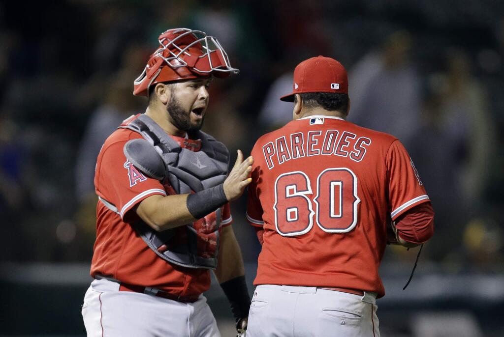 Los Angeles Angels' Juan Graterol, left, celebrates the 8-7 win over the Oakland Athletics with Eduardo Paredes (60) at the end of a baseball game Tuesday, Sept. 5, 2017, in Oakland, Calif. (AP Photo/Ben Margot)