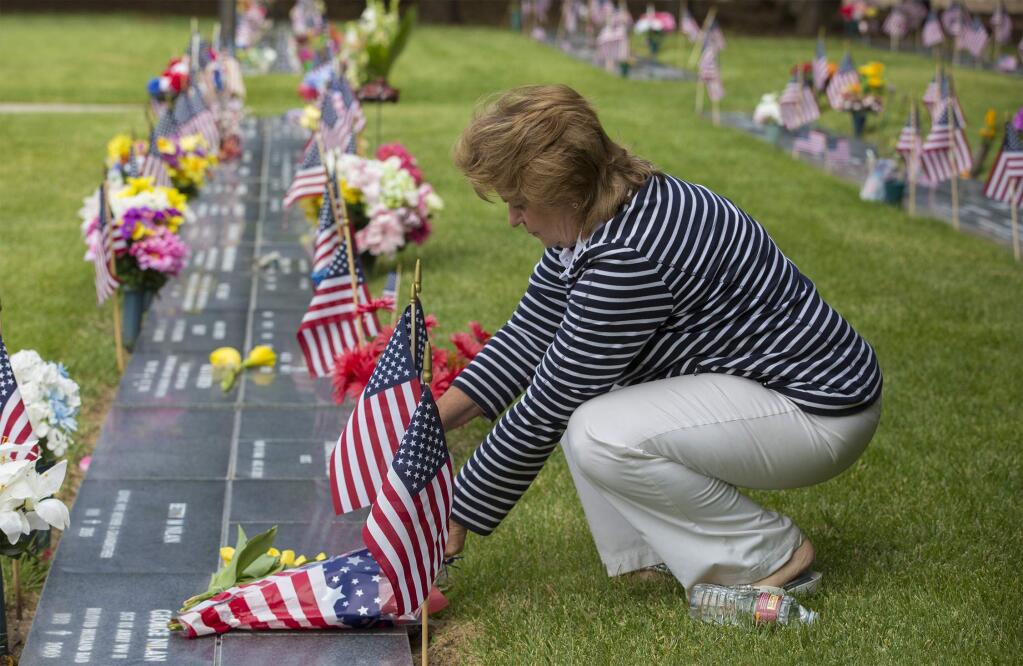 Joanne Lely places places flowers to honor Dirk Lely. The annual Sonoma Valley Memorial Day observance took place at the Sonoma Veterans Memorial Park on Monday, May 29. (Photo by Robbi Pengelly/Index-Tribune)