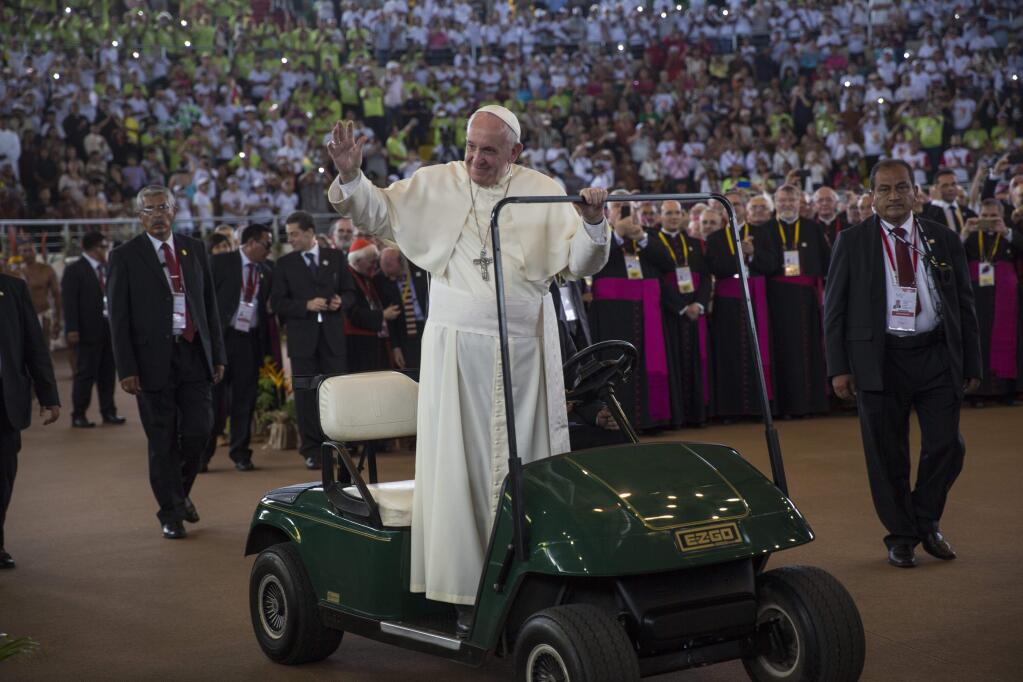 Pope Francis waves from a golf cart as he is driven inside a coliseum during a meeting with indigenous groups from the Peruvian Amazon, in Puerto Maldonado, Madre de Dios province, Peru, Friday, Jan. 19, 2018. Standing with thousands of indigenous Peruvians, Francis declared the Amazon the 'heart of the church' and called for a three-fold defense of its life, land and cultures. (AP Photo/Rodrigo Abd)