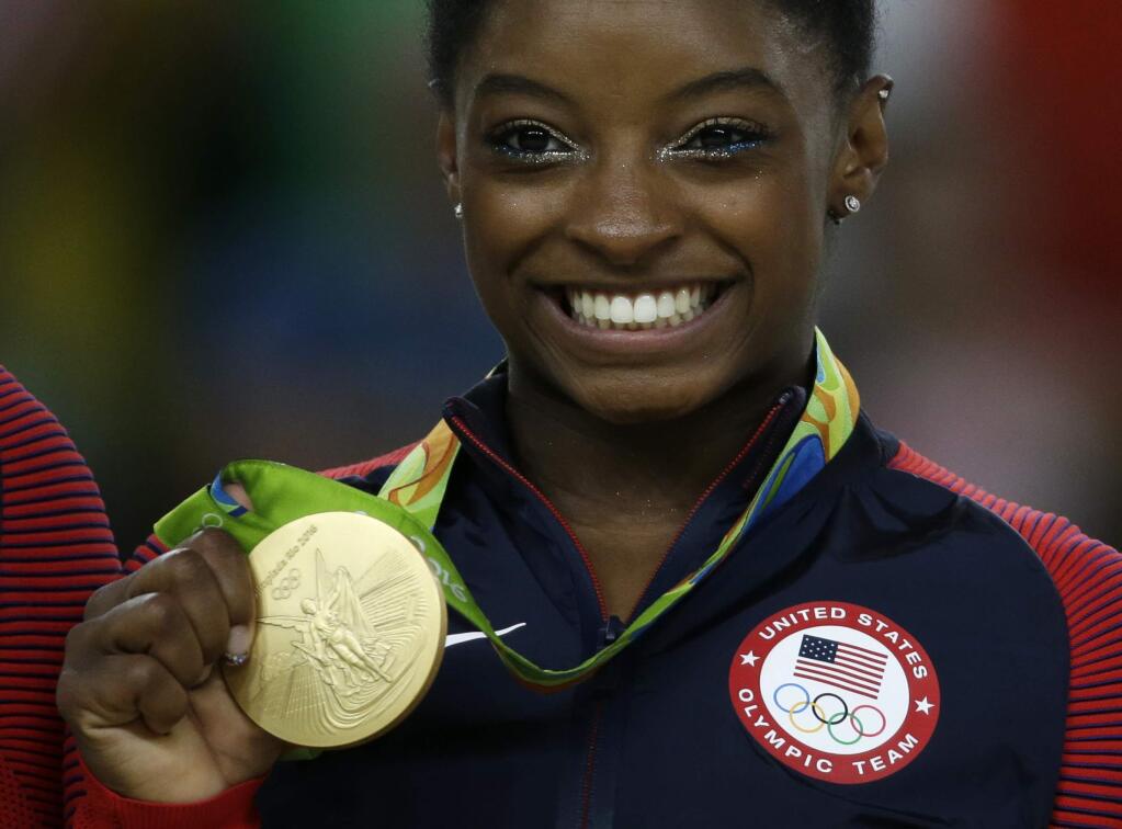 United States' Simone Biles displays her gold medal for floor during the artistic gymnastics women's apparatus final at the 2016 Summer Olympics in Rio de Janeiro, Brazil, Tuesday, Aug. 16, 2016. (AP Photo/Rebecca Blackwell)