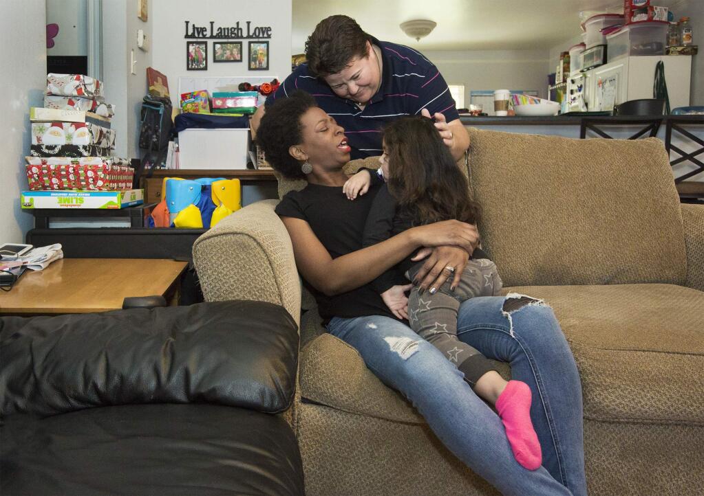 Mimi and Petie at home with their daughter, adopted out of the foster care system this year. (Photo by Robbi Pengelly/Index-Tribune)