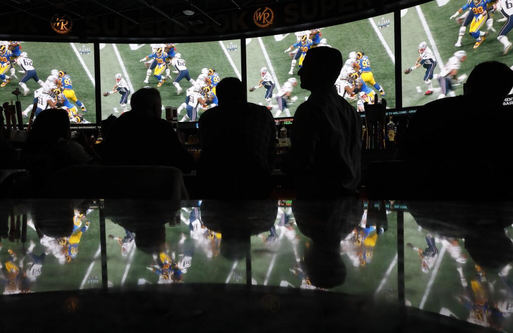 People watch Super Bowl LIII at the Westgate Superbook sportsbook, Sunday, Feb. 3, 2019, in Las Vegas. (AP Photo/John Locher)