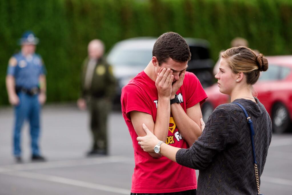 Marysville Pilchuck High School junior Carsyn Yorkoski, center, tearfully reunites with his sister, Kyla Yorkoski, right, at a reunification center near the scene of a school shooting that left two dead and four wounded Friday, Oct. 24, 2014, at Marysville Pilchuck High School in Marysville, Wash. (AP Photo/seattlepi.com, Jordan Stead)