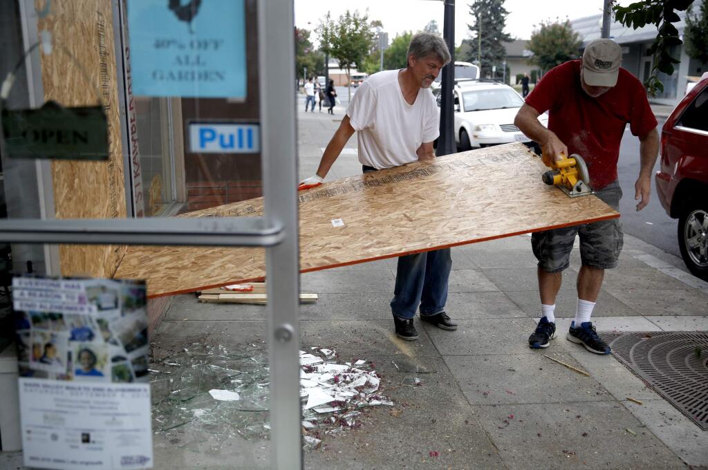 Mark Van Til, left, and Richard Trimble try to repair broken windows at The Roost Napa after a 6.0 earthquake in on Sunday, August 24, 2014 in Napa, California. (BETH SCHLANKER/ The Press Democrat)