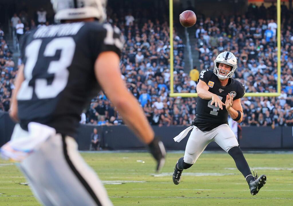 Oakland Raiders quarterback Derek Carr delivers a touchdown pass to wide receiver Hunter Renfrow against the Detroit Lions in Oakland on Sunday, Nov. 3, 2019. (Christopher Chung / The Press Democrat)