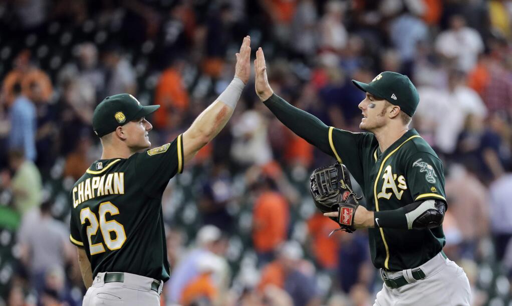 The Oakland Athletics' Matt Chapman, left, and Mark Canha celebrate after a win against the Houston Astros Thursday, July 12, 2018, in Houston. (AP Photo/David J. Phillip)