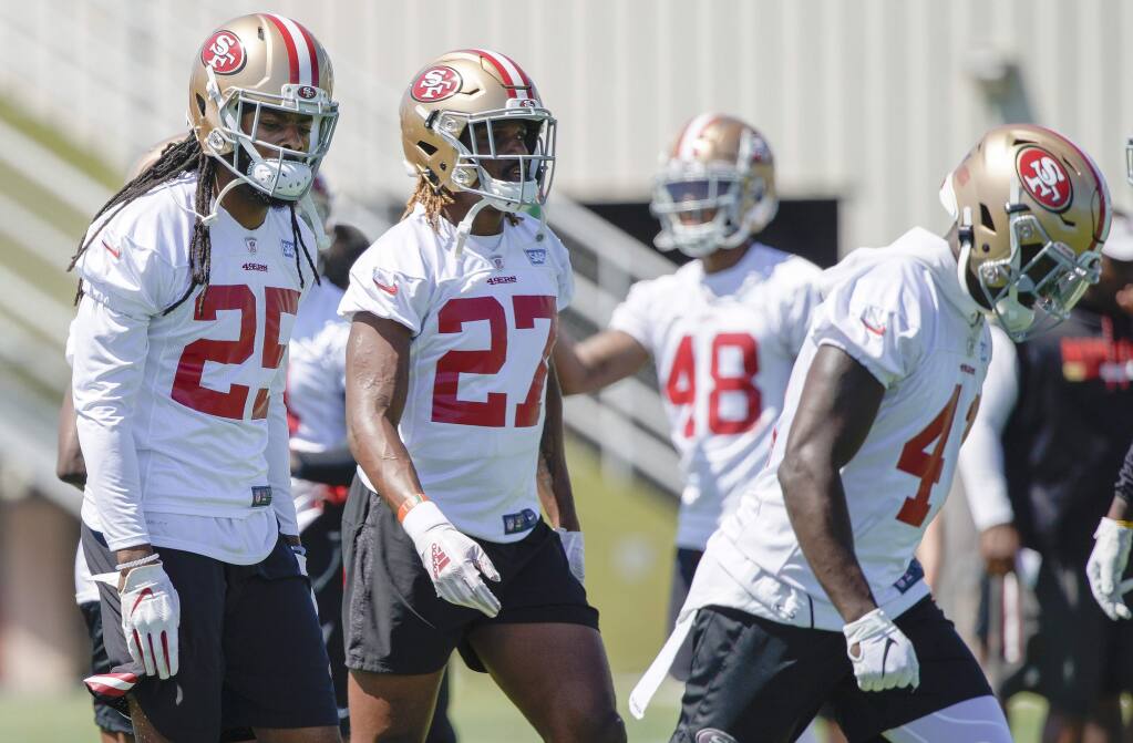 The San Francisco 49ers' Richard Sherman, left, Adrian Colbert and Emmanuel Moseley, right, warm up during practice at the team's training facility in Santa Clara, Tuesday, June 11, 2019. (AP Photo/Tony Avelar)