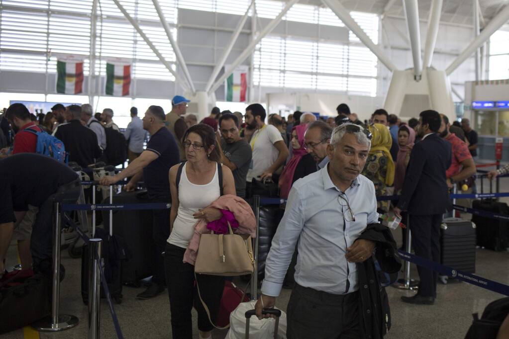 Travelers join a queue to check in at the Irbil International Airport, in Iraq, Friday, Sept. 29, 2017. Many travelers boarded the last flights out of the cities of Irbil and Sulaymaniyah as an Iraqi government order to halt all international flights in Kurdish territory was set to kick in on Friday. (AP Photo/Bram Janssen)