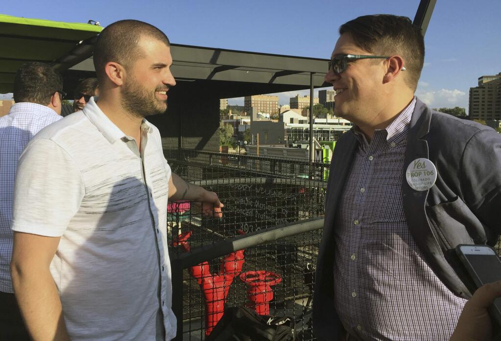 In this Sept. 22, 2016 photo, Denver marijuana consultant Kayvan Khalatbhari, left, chats with a lobbyist Joe Megysy at a fundraiser for marijuana policy reform in Denver. Business owners are replacing idealists in the pot-legalization movement as the nascent marijuana industry creates a donor base of entrepreneurs willing to spend to change drug policy. (AP Photo/Kristen Wyatt)