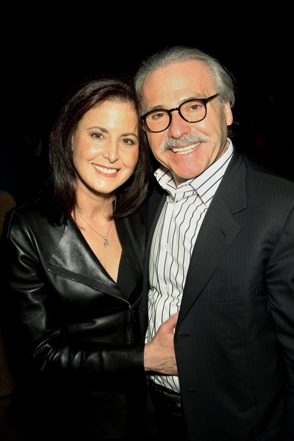 In this Jan. 31, 2014 photo, David Pecker, Chairman and CEO of American Media, poses with his wife, Karen Pecker, at the Shape & Men's Fitness Super Bowl Party in New York. The Aug. 21, 2018 plea deal reached by Donald Trump's former attorney Michael Cohen has laid bare a relationship between the president and Pecker, whose company publishes the National Enquirer. Besides detailing tabloid's involvement in payoffs to porn star Stormy Daniels and Playboy Playmate Karen McDougal to keep quiet about alleged affairs with Trump, court papers showed how David Pecker, a longtime friend of the president, offered to help Trump stave off negative stories during the 2016 campaign. (Marion Curtis via AP)