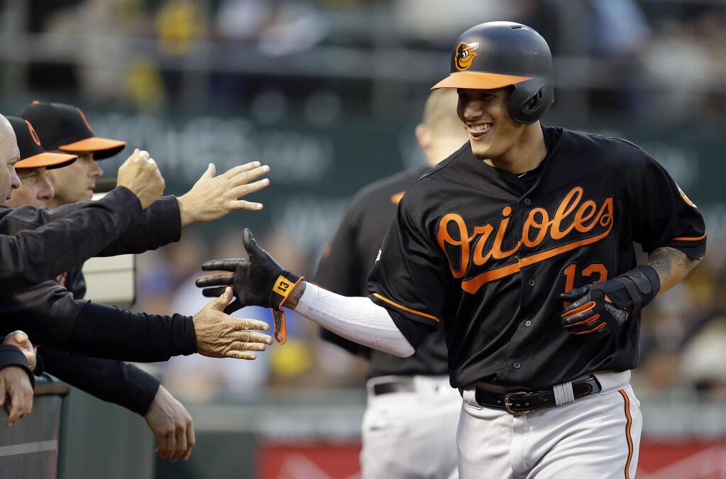 Baltimore Orioles' Manny Machado, right, is congratulated after scoring against the Oakland Athletics during the fourth inning of a baseball game Friday, Aug. 11, 2017, in Oakland, Calif. (AP Photo/Ben Margot)