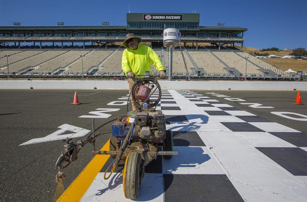 United Striping 101's Joe Caprara paints the yellow line at the Start/Finish. It's NASCAR weekend, and on Thursday morning preparations at Sonoma Raceway were in high gear. (Robbi Pengelly)