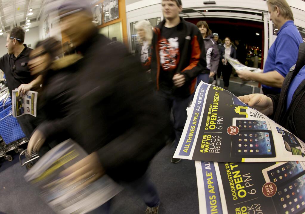 FILE - In this Thursday, Nov. 28, 2013, file photo, shoppers enter a Best Buy as the store opens on Thanksgiving Day, in Overland Park, Kan. Despite positive economic signs, holiday shoppers will only spend if they get big discounts. (AP Photo/Charlie Riedel, File)