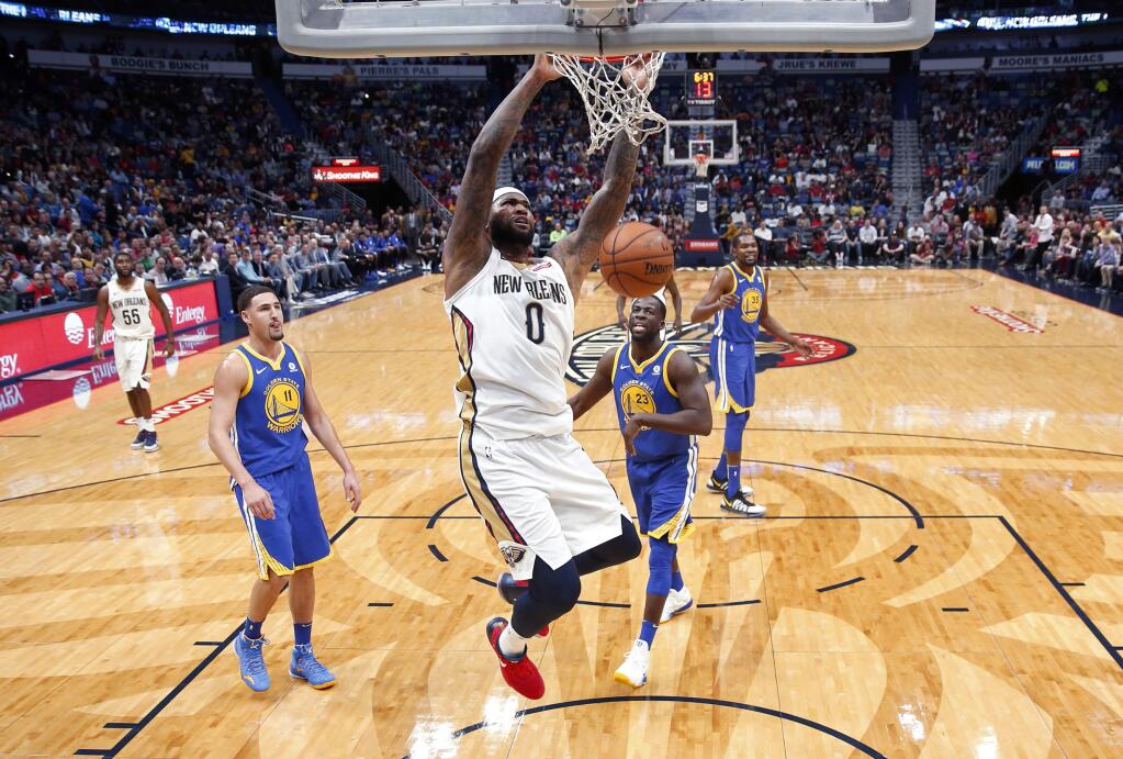 New Orleans Pelicans center DeMarcus Cousins (0) slam dunks in front of Golden State Warriors forward Draymond Green (23) and guard Klay Thompson (11) in the first half of an NBA basketball game in New Orleans, Monday, Dec. 4, 2017. (AP Photo/Gerald Herbert)