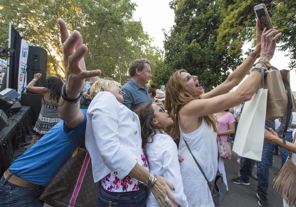 A family group takes selfies in front of the band.The ever-festive Sonoma City Party took place on Friday, Aug 18., and the Plaza was jammed with picnickers. Several bands played throughout the evening. (Photo by Robbi Pengelly/Index-Trilbune)