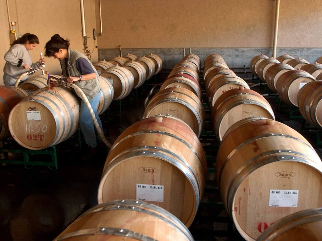 Cellar workers Isabel Rosillo, left, and Christina Martinez fill oak barrels at Simi WInery in Healdsburg, another Constellation Brands winery.