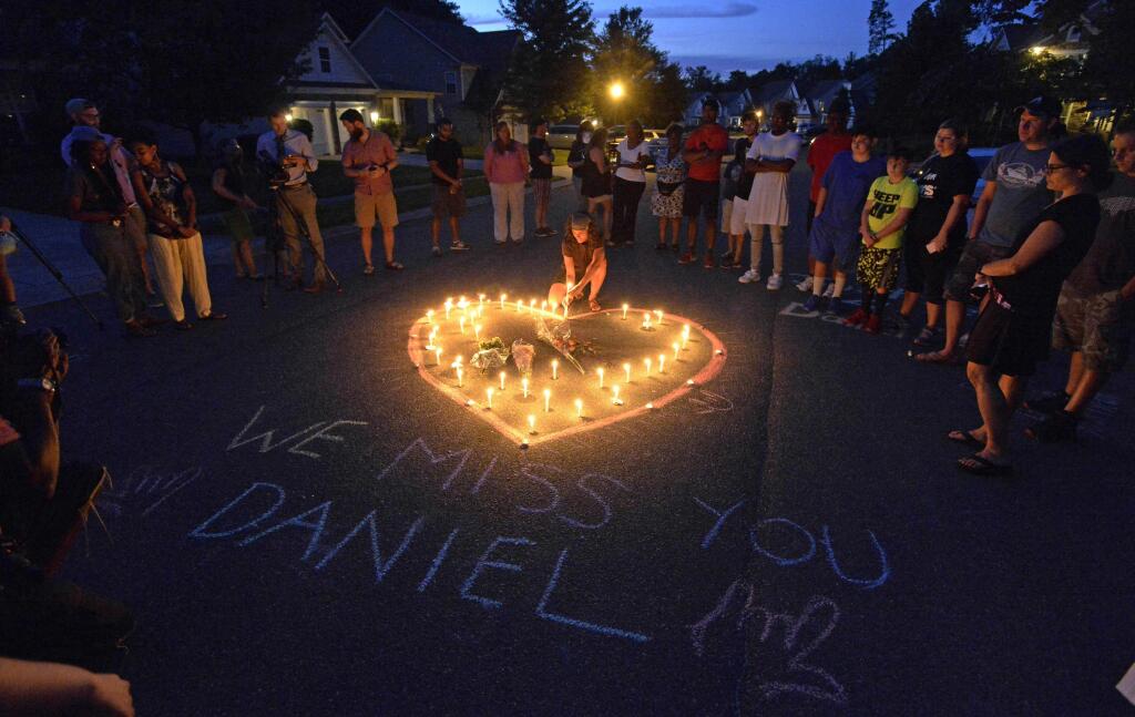 Friends and family of Daniel Harris gather around a heart drawn onto Seven Oaks Drive during a candlelight vigil to remember Harris, a deaf motorist who was shot and killed by a state trooper, Monday, Aug. 22, 2016 in Charlotte, N.C. Harris, a deaf man who was shot and killed by a North Carolina state trooper after he didnt stop for the officers blue lights was unarmed and likely did not understand the officers commands, the slain mans family says. (David T. Foster III/The Charlotte Observer via AP)