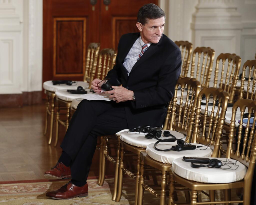 In this photo taken Feb. 10, 2017, then-National Security Adviser Michael Flynn sits in the front row in the East Room of the White House, in Washington. Attorneys for Flynn say that a daily 'escalating public frenzy against him' and the Justice Department's appointment of a special counsel has created a legally dangerous environment for him to cooperate with a Senate investigation. That's according to a letter obtained by The Associated Press sent Monday by Flynn's legal team to the Senate Intelligence committee. It lays out the case for Flynn, the former national security adviser, to invoke his right against self-incrimination. (AP Photo/Carolyn Kaster)