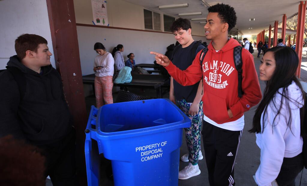 From left, Piner High School teammates Donovan Carrillo, Noah Hatfield and Yonaton Isack greet one another during lunch break, Thursday, Nov. 21, 2019, at right is Lezkena Nhock. Football players are part of a recycling program at the school, and help students sort out trash and recycling. (Kent Porter / The Press Democrat)