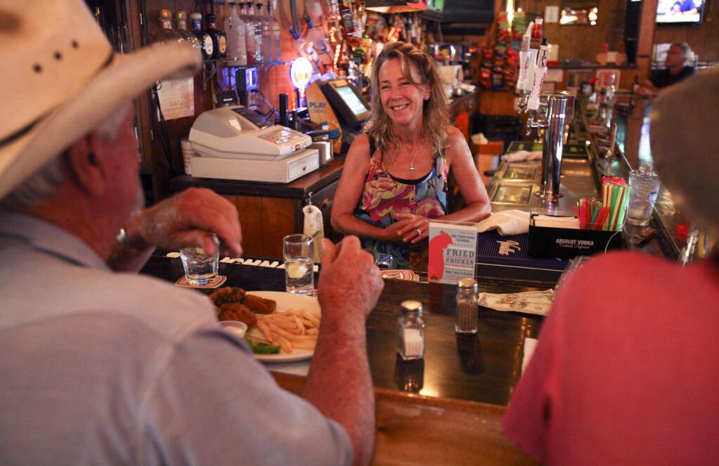 The new owner of Twin Oaks Tavern Sheila Groves-Tracey chats with longtime customers Nick Bursio, left, and Paul Gilchrist, both of Penngrove on Monday July 7, 2014.