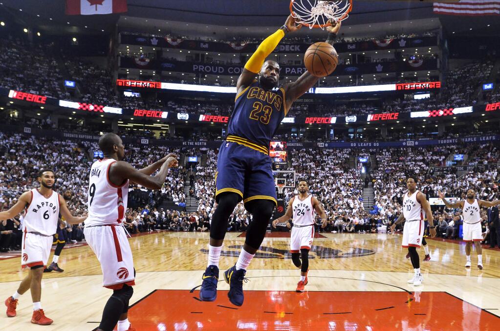 Cleveland Cavaliers forward LeBron James (23) slam dunks the ball past Toronto Raptors forward Serge Ibaka (9) on Sunday, May 7, 2017. (Nathan Denette/The Canadian Press via AP)