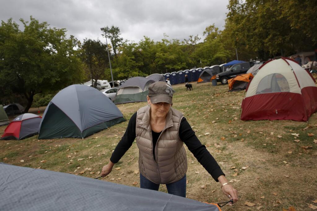 Volunteer Ann Minaglia helps assemble a tent before the start of rain at the Napa County Fairgrounds in Calistoga, on Wednesday, September 16, 2015. (BETH SCHLANKER/ The Press Democrat)