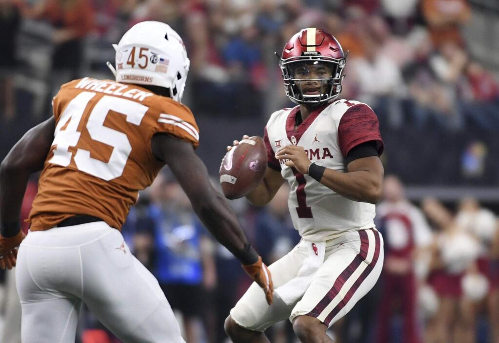 Oklahoma quarterback Kyler Murray, right, looks to pass as Texas linebacker Anthony Wheeler applies pressure during the first half of the Big 12 conference championship game on Saturday, Dec. 1, 2018, in Arlington, Texas. (AP Photo/Jeffrey McWhorter)