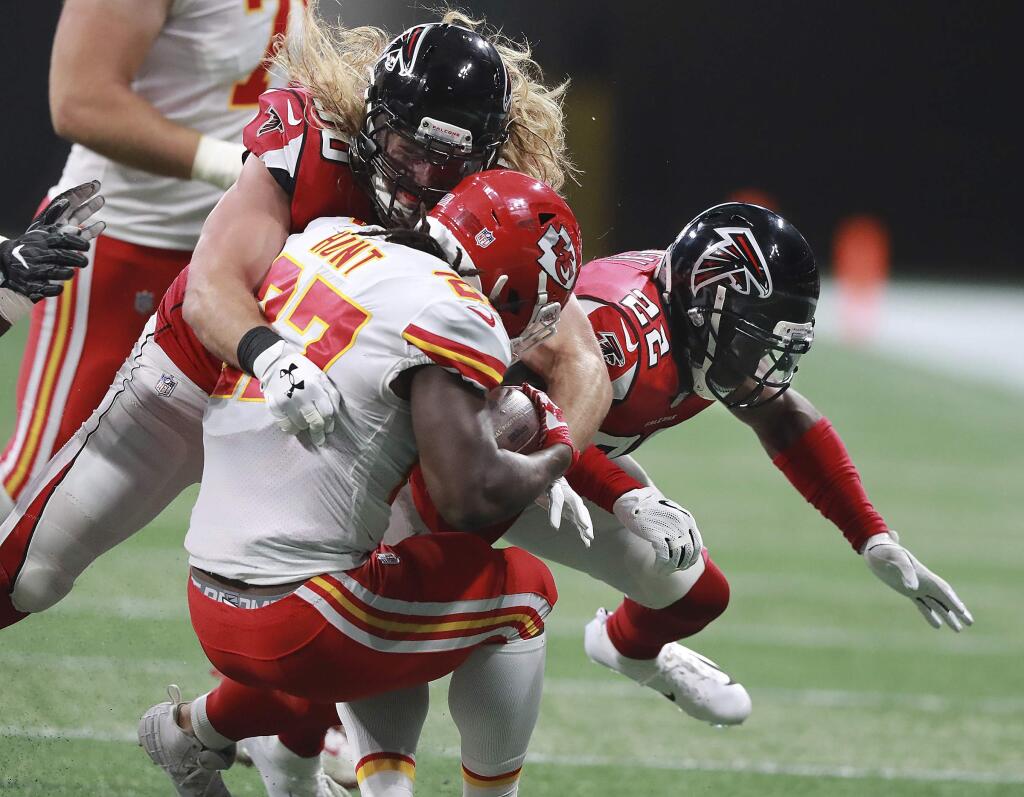 Atlanta Falcons safety Keanu Neal, right, and defensive end Brooks Reed hit Kansas City Chiefs running back Kareem Hunt during the first quarter of a preseason game Friday, Aug, 17, 2018, in Atlanta. Neal was called for a penalty on the hit. (Curtis Compton/Atlanta Journal-Constitution via AP)