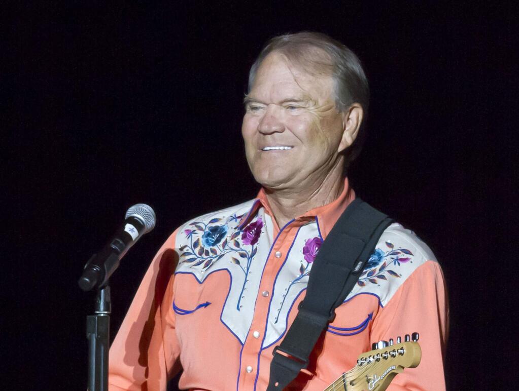 FILE - This Sept. 6, 2012 file photo shows singer Glen Campbell performing during his Goodbye Tour in Little Rock, Ark. Campbell, the grinning, high-pitched entertainer who had such hits as 'Rhinestone Cowboy' and spanned country, pop, television and movies, died Tuesday, Aug. 8, 2017. He was 81. Campbell announced in June 2011 that he had been diagnosed with Alzheimer's disease. (AP Photo/Danny Johnston, File)