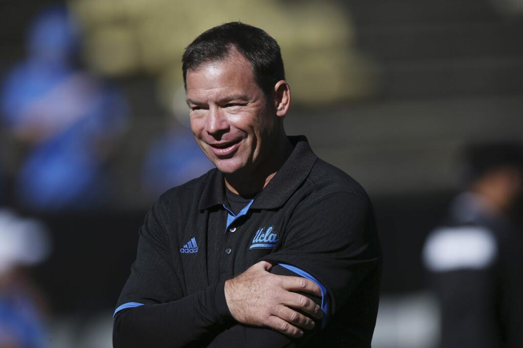 FILE - In this Saturday, Oct. 25, 2014 photo, UCLA head coach Jim Mora looks on as his team warms up before facing Colorado in the first quarter of an NCAA football game in Boulder, Colo. The University of California had 28 employees who made more than $1 million last year, an elite group comprised of athletic coaches, doctors and hospital chief executives. (AP Photo/David Zalubowski, File)