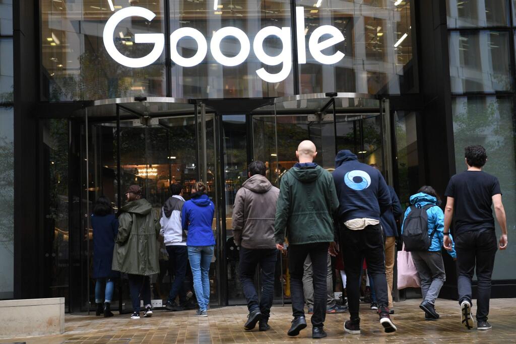 People outside the Google offices in Granary Sqaure, London, Thursday Nov. 1, 2018. Hundreds of Google engineers and other workers walked off the job Thursday morning to protest the internet company's lenient treatment of executives accused of sexual misconduct. Employees were seen staging walkouts at offices in Tokyo, Singapore, London, and Dublin. (Stefan Rousseau/PA via AP)