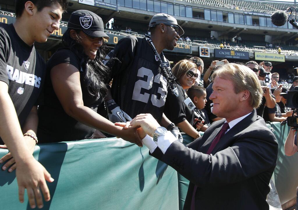 NFL broadcaster and former Oakland Raiders head coach Jon Gruden greets fans before an NFL preseason football game between the Oakland Raiders and the Dallas Cowboys in Oakland, Calif., Monday, Aug. 13, 2012. (AP Photo/Tony Avelar)