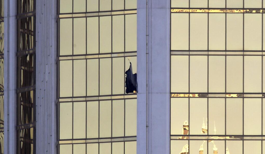 A broken window is seen at the Mandalay Bay resort and casino Monday, Oct. 2, 2017, on the Las Vegas Strip following a deadly shooting at a music festival in Las Vegas. (AP Photo/Chris Carlson)