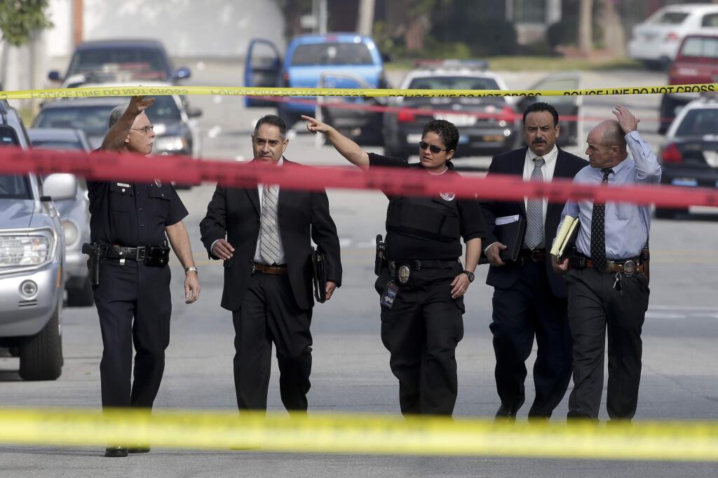 FILE - In this Feb. 7, 2013 file photo, law enforcement members look over the scene of an officer involved shooting in Torrance, Calif. From a body punch that leaves a bruise to a fatal shooting, all 800 police departments in California must begin using a new online tool launched Thursday, Sept, 15, 2016 to help track and report every time they use force that causes injury. The tool's developers hail it as the first statewide dataset of its kind in the country and a model for other states.(AP Photo/Chris Carlson, File)