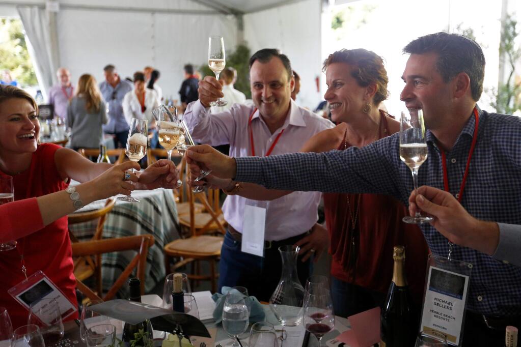 Wendy Heilmann, second from right, of Pebble Beach Resorts shares a celebratory toast with her tablemates after making the winning $41,000.00 bid on 20 cases of Williams Selyem Winery 2015 35th Anniversary Blend Pinot Noir during the Sonoma County Barrel Auction at Vintner's Inn in Santa Rosa, California on Friday, April 29, 2016. (Alvin Jornada / The Press Democrat)