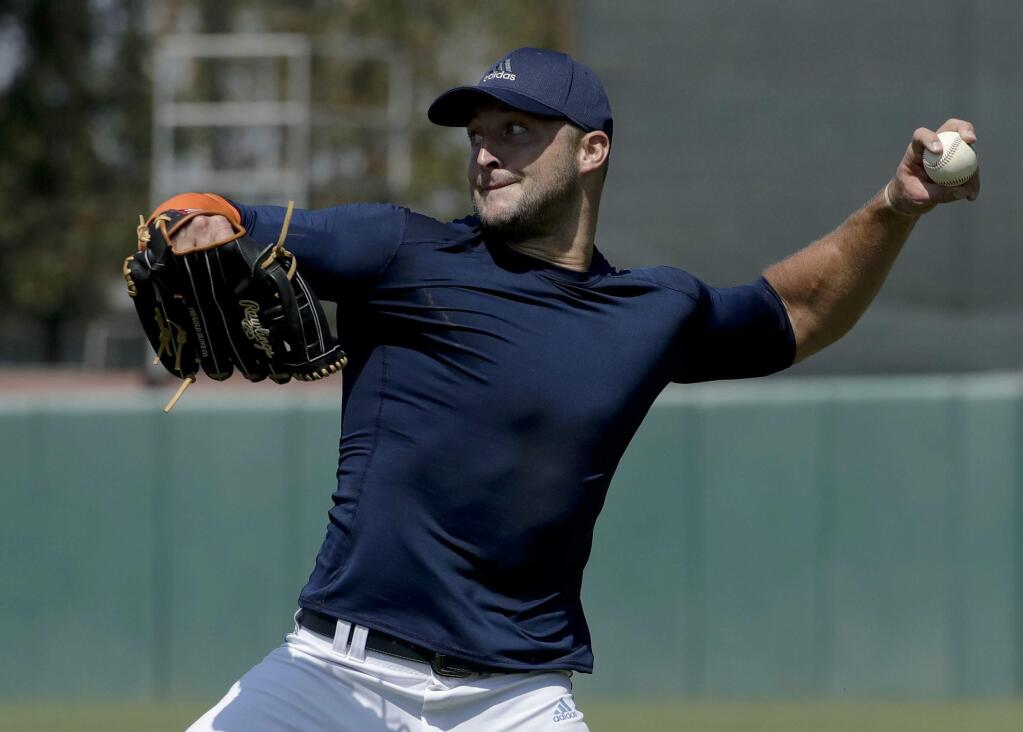 Former NFL quarterback, Tim Tebow throws a ball for baseball scouts and the media during a showcase on the campus of the University of Southern California, Tuesday, Aug. 30, 2016 in Los Angeles. The Heisman Trophy winner works out for a big gathering of scouts on USC's campus in an attempt to start a career in a sport he hasn't played regularly since high school. (AP Photo/Chris Carlson)