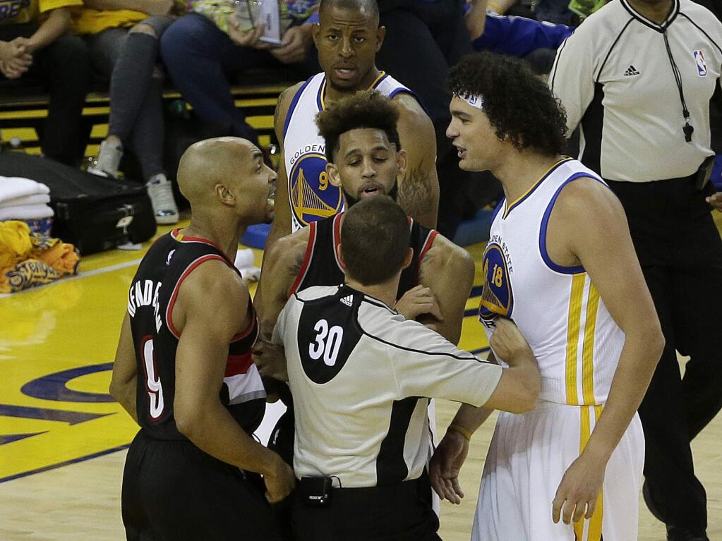 Referee John Goble (30) separates Portland Trail Blazers guard Gerald Henderson, left, and Golden State Warriors forward Anderson Varejao during the second half in Game 1 of a second-round NBA basketball playoff series in Oakland, Calif., Sunday, May 1, 2016. The Warriors won 118-106. (AP Photo/Jeff Chiu)