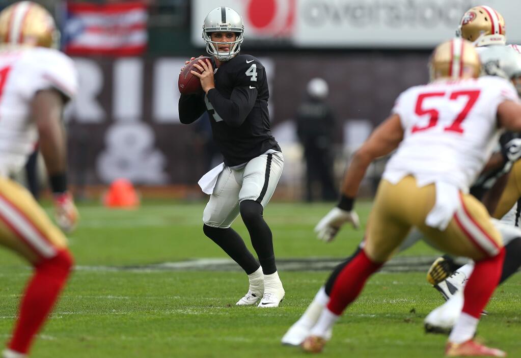 Oakland Raiders quarterback Derek Carr drops back for a pass against the San Francisco 49ers, during their game in Oakland on Sunday, December 7, 2014. The Raiders defeated the 49ers 24-13.(Christopher Chung/ The Press Democrat)