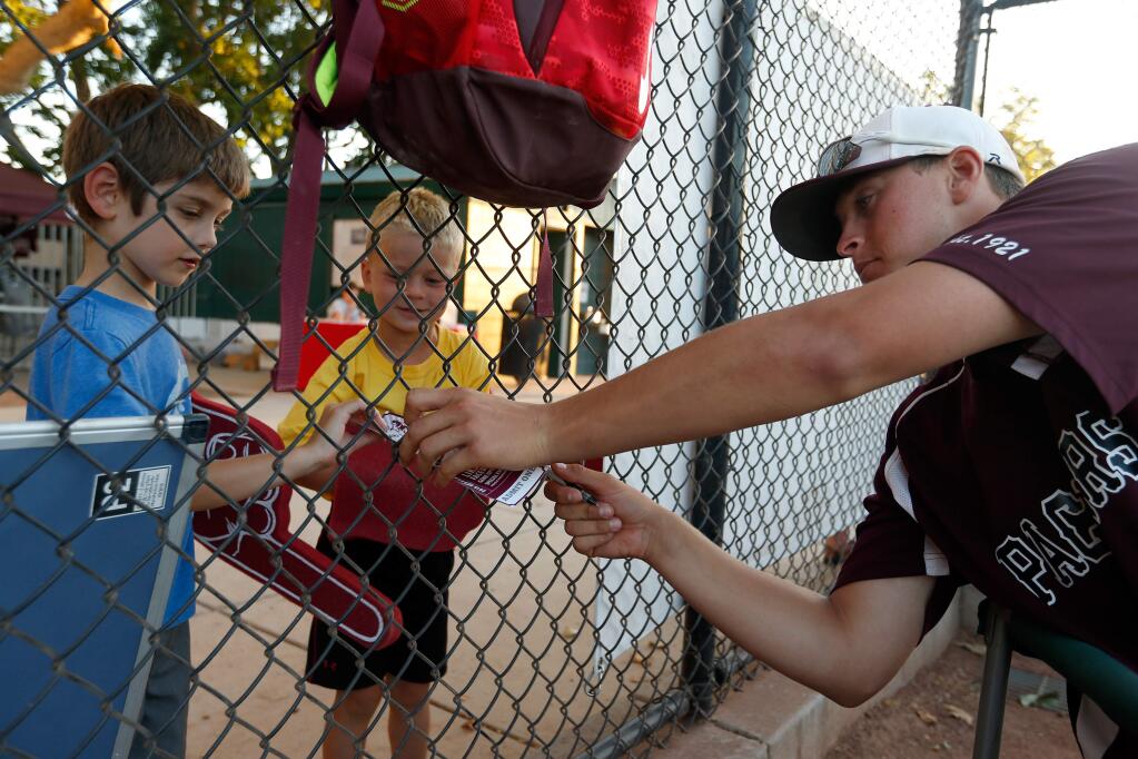 Young Prune Packers fans Ethan Newton, 6, left, and Chase Desmond, 5, get autographs from pitcher Matt Campbell during the Healdsburg Prune Packers baseball game against the Humboldt Crabs, in Healdsburg, California on Wednesday, June 22, 2016. (Alvin Jornada / The Press Democrat)