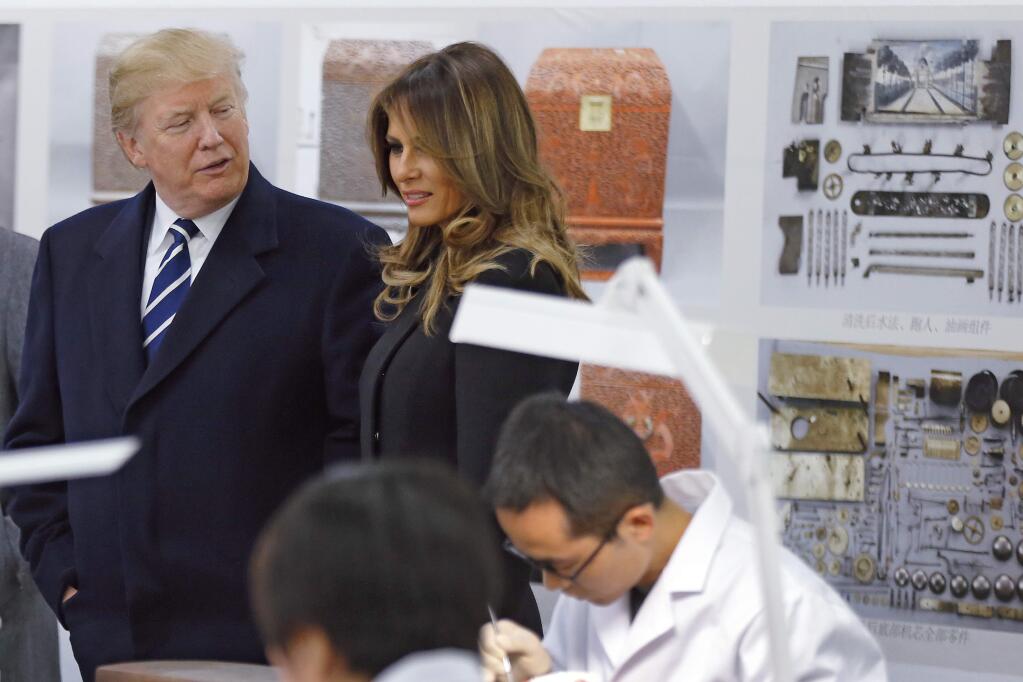 U.S. President Donald Trump, chats with U.S. first lady Melania Trump as they tour the Conservation Scientific Laboratory of the Forbidden City in Beijing, China, Wednesday, Nov. 8, 2017. (AP Photo/Andy Wong, Pool)