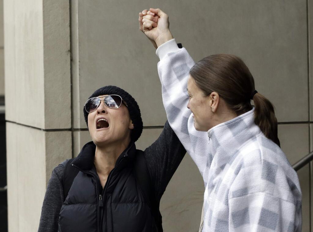 Supporters celebrate after hearing a verdict outside federal court in Portland, Ore., Thursday, Oct. 27, 2016. A jury exonerated brothers Ammon and Ryan Bundy and five others of conspiring to impede federal workers from their jobs at the Malheur National Wildlife Refuge. (AP Photo/Don Ryan)