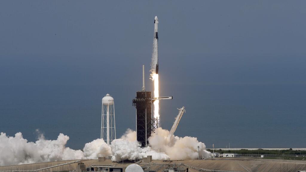 The SpaceX Falcon 9 and the Crew Dragon capsule, with NASA astronauts Bob Behnken and Doug Hurley onboard, lifts off from the Kennedy Space Center in Cape Canaveral, Florida. (CHRIS O'MEARA / Associated Press)