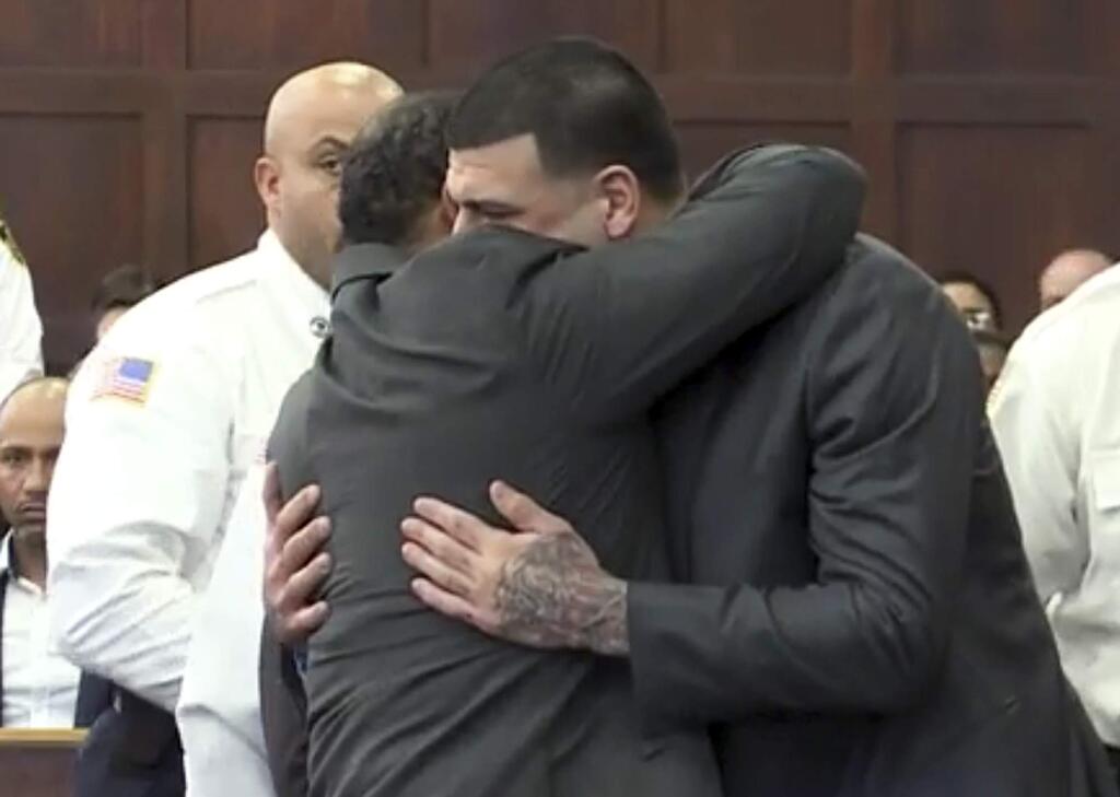 In this still image from video, Aaron Hernandez, center, is hugged by defense attorney Ronald Sullivan, Friday, April 14, 2017, in court in Boston, after being found not guilty of murder in the 2012 shootings of two men in a drive-by shooting in Boston. (WHDH-TV via AP, Pool)