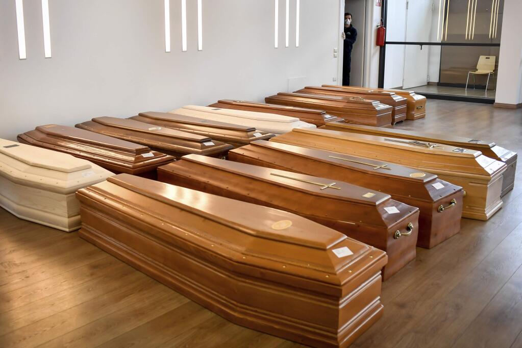 Coffins are lined up on the floor in the Crematorium Temple of Piacenza, Northern Italy, saturated with corpses awaiting cremation due to the coronavirus emergency Monday, March 23, 2020. For most people, the new coronavirus causes only mild or moderate symptoms. For some it can cause more severe illness, especially in older adults and people with existing health problems. (Claudio Furlan/LaPresse via AP)