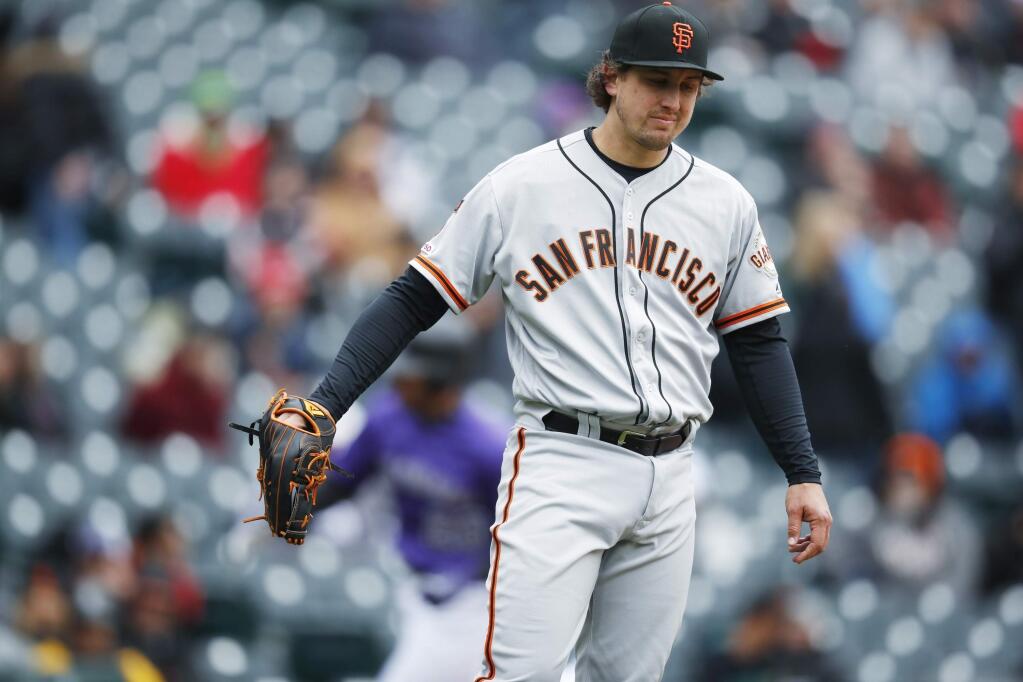 San Francisco Giants starting pitcher Derek Holland calls for a new ball after giving up a two-run home run to Colorado Rockies' Ian Desmond in the second inning of a baseball game Thursday, May 9, 2019, in Denver. (AP Photo/David Zalubowski)