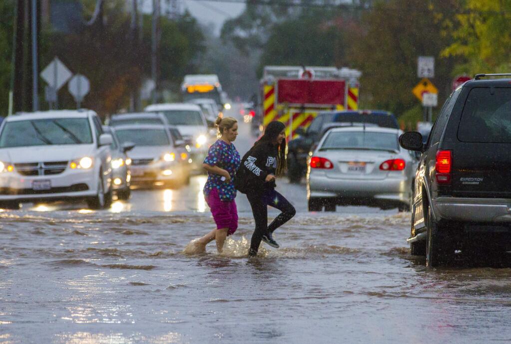 As the storm passed through the valley and city streets flooded, this was the scene at MacArthur and Broadway, as high school students made their way home. (Photo by Robbi Pengelly/Index-Tribune)