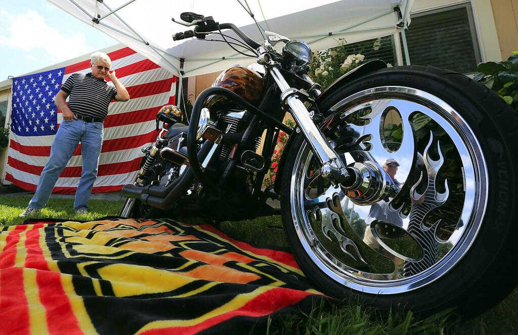 PHOTO: 1 by JOHN BURGESS / The Press Democrat -Paul Giovannetti checks out a KISS Tribute Harley Davidson during a pre-Memorial Day gathering at Gary Mills' Cloverdale home. The motorcycle is owned by Vietnam veteran Gary Greenough of Santa Rosa, who noted the band regularly visits wounded troops.
