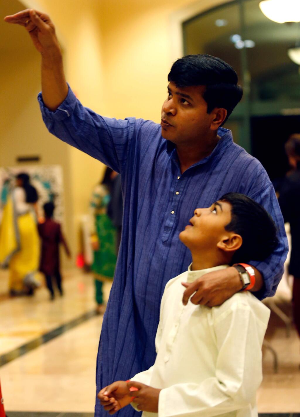 Atul Patil talks with his son Arav, 9, during the North Bay Indian American Association's Diwali Festival at the Jackson Theater in Santa Rosa, California on Saturday, November 12, 2016. (Alvin Jornada / The Press Democrat)