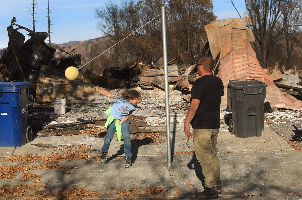Louis Pell and his eight-year-old daughter Lilly, in front of their burned home, Tuesday Nov. 7, 2017 in Santa Rosa's Coffey Park. (Kent Porter / The Press Democrat) 2017